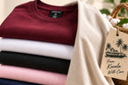 The five t-shirts folded in a stack showing each colour